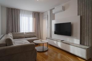 uma sala de estar com um sofá e uma TV de tela plana em Hedonist Garden Luxury Apartments em Doboj