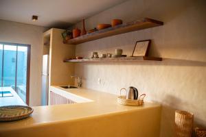 una cucina con bancone, lavandino e scaffali di Casa Brisa - Villa Vento a Camocim