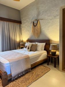 una camera da letto con un letto grande con lenzuola bianche di Casa Brisa - Villa Vento a Camocim