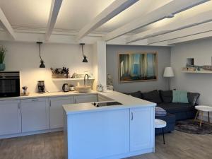a kitchen and a living room with a couch at Häuschen am Meer in Sierksdorf +13 photos