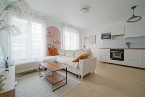 een woonkamer met een witte bank en een tafel bij Parking private free - Family cocoon - Quiet - 7 min Tram T5 in Saint-Denis +20 foto's