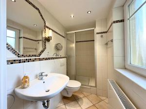 a bathroom with a sink and a toilet and a shower at Strandoase Sierksdorf Strandoase Sonnenbucht in Hansaland