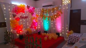 a party with a red table with balloons and lights at JJs PARK INN in Chennai