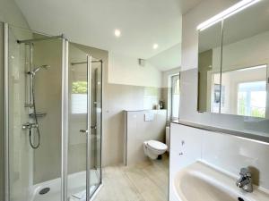 a bathroom with a shower and a toilet and a sink at Meerblick in Hansaland +11 photos