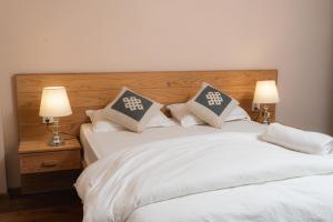 two beds with white sheets and pillows in a bedroom at Maitreya Homestay in Pātan