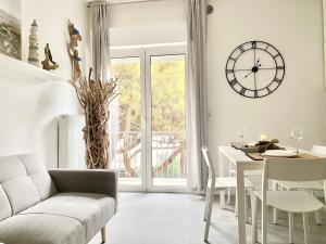 Civico 148- Lido di Jesolo - Per Famiglie في ليدو دي يسولو: غرفة معيشة مع طاولة وساعة على الحائط