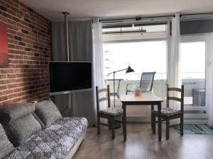 un soggiorno con un divano e un tavolo con una TV di Panoramic Sierksdorf Meer Loft a Hansaland