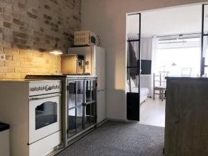una cucina con elettrodomestici bianchi e un muro di mattoni di Panoramic Sierksdorf Meer Loft a Hansaland