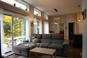 a living room with a couch and a table at Spa - Lake access - Absolute Comfort - L'Herisson in Chertsey
