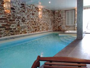 a swimming pool with a bench in a brick wall at la Maison d'Odette et Daniel in Vitrac