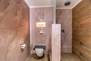 ein Badezimmer mit einer weißen Toilette in einem Zimmer in der Unterkunft Aria Stay in Drama + 15 Fotos