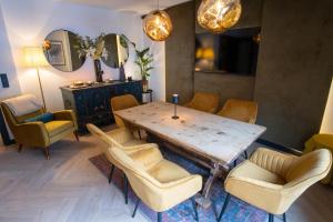 una sala da pranzo con tavolo, sedie e uno specchio di Appartements Cafe Schneider a Sankt Anton am Arlberg