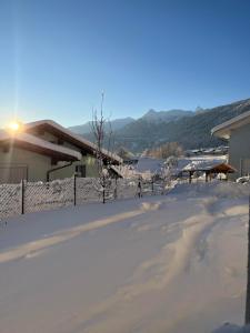 a driveway covered in snow with a house in the background at Ferienwohnung Thöny in Vandans
