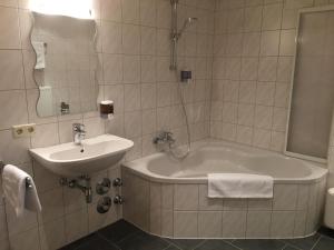 a bathroom with a bath tub and a sink at Ferienwohnung Thöny in Vandans +27 photos