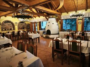 um restaurante com mesas e cadeiras e um vaso grande em Forster Vadászkastély és Szálloda em Bugyi