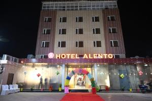 a hotel entrance with a hotel alliance sign in front of it at Hotel Alento in Jamnagar