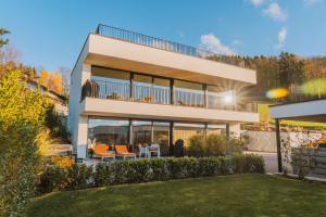 a house with a balcony with orange chairs at ORANGE LOUNGE Attersee in Weyregg