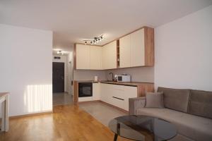 uma sala de estar com um sofá e uma cozinha em Hedonist Garden Luxury Apartments em Doboj