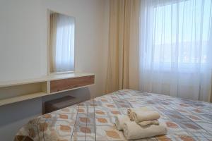 um quarto com uma cama com duas toalhas em Hedonist Garden Luxury Apartments em Doboj