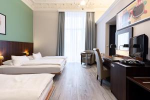 a hotel room with two beds and a desk at Garner Hotel Hamburg - Graf Moltke by IHG in Hamburg +175 photos
