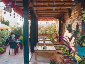 an outdoor patio with wooden tables and chairs at Newa Home in Kathmandu