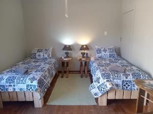 a room with two beds and a table with lamps at Kliplelie Selfsorg in Tulbagh