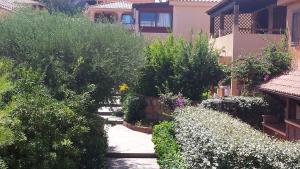a garden with bushes and flowers next to a building at Appartamenti Baia Smeralda in Santa Marinella
