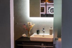 un bagno con lavandino e specchio di Appartements Cafe Schneider a Sankt Anton am Arlberg Altre 63 foto