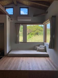una grande camera con una grande finestra e un letto di 月みるいえ ad Akaogi