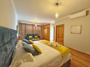 a bedroom with a large bed with yellow pillows at Arco da Calheta Villa in Arco da Calheta +31 photos