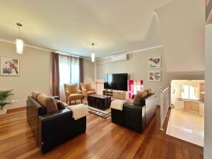a living room with two couches and a television at Arco da Calheta Villa in Arco da Calheta