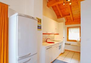 eine Küche mit einem weißen Kühlschrank und einer Spüle in der Unterkunft Chalet Gasparoli in La Tzoumaz