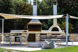 a patio with a couch and an outdoor grill at Thalmargia Villas, with Pool, Hot Tub & Ultimate Peace, By ThinkVilla in Garazo
