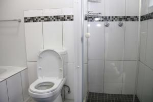 ein weißes Badezimmer mit Toilette und Dusche in der Unterkunft Lazarett Loft Modern Apartment in Windhoek