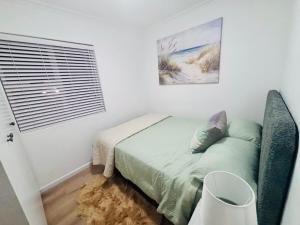 a small bedroom with a bed and a window at Stanley's Place at 212 Salerno in Cape Town +23 photos