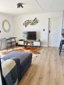 a living room with a couch and a flat screen tv at Stanley's Place at 212 Salerno in Cape Town