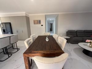 a living room with a wooden table and chairs at Wellard Nest- Perth- Newly built house, walk to the shops and train station- Close to Rockingham and motorplex in Wellard
