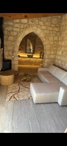a living room with a stone fireplace and a bed at ELINN traditional suits in Kathikas