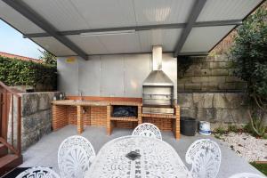 a patio with a grill and a table and chairs at Casa São Domingos in Travanca