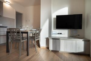 カスティオーネ・デッラ・プレゾラーナにあるBratto Relax Apartmentsのダイニングルーム(テーブル、椅子、薄型テレビ付)