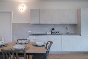 カスティオーネ・デッラ・プレゾラーナにあるBratto Relax Apartmentsのキッチン(木製テーブル、椅子、キッチンカウンター付)