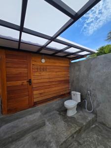 ein Badezimmer mit Toilette unter einem Dach in der Unterkunft The Mawun Lombok in Selong Belanak