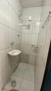 een witte badkamer met een wastafel en een douche bij Nunes stay in Prado