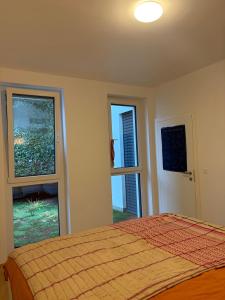 a bedroom with a bed and two windows at A bright spacious & convenient 2 brm TownHouse in Größing +3 photos