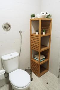 a bathroom with a toilet and a shelf with towels at DaKing in Vila do Conde +2 photos