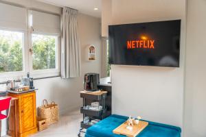 a living room with a television on the wall at The Gentle Arch Schiphol Amsterdam in Aalsmeer
