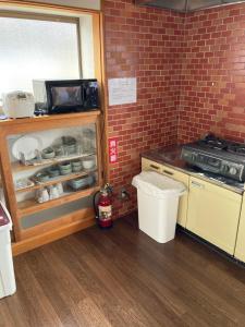 een keuken met een koelkast en een fornuis bij 7Daysあさひや in Matsuzaki