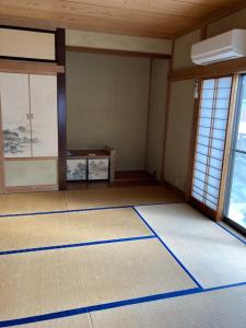 een lege kamer met blauwe lijnen op de vloer bij 7Daysあさひや in Matsuzaki