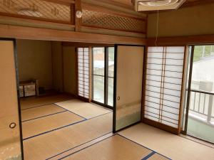 een lege kamer met glazen deuren en ramen bij 7Daysあさひや in Matsuzaki +2 foto's