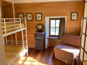 Un dormitorio con dos literas y una ventana. en Sassiglioni Vacanze, en Sassiglioni
